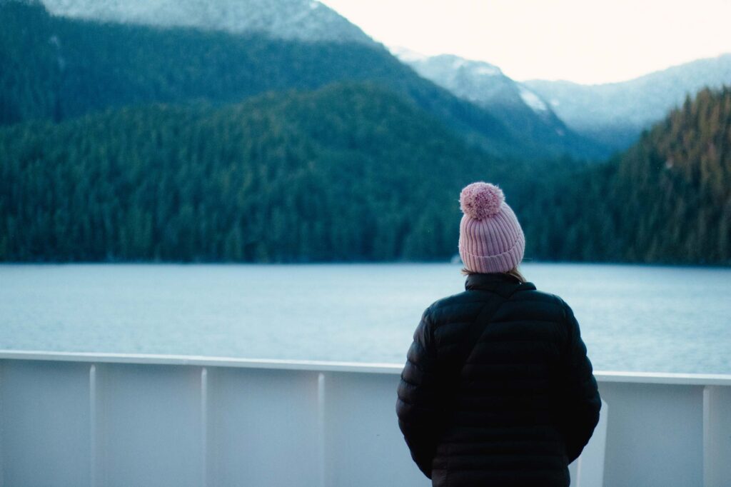 Woman with pink beanie looking off the inside passage ferry.